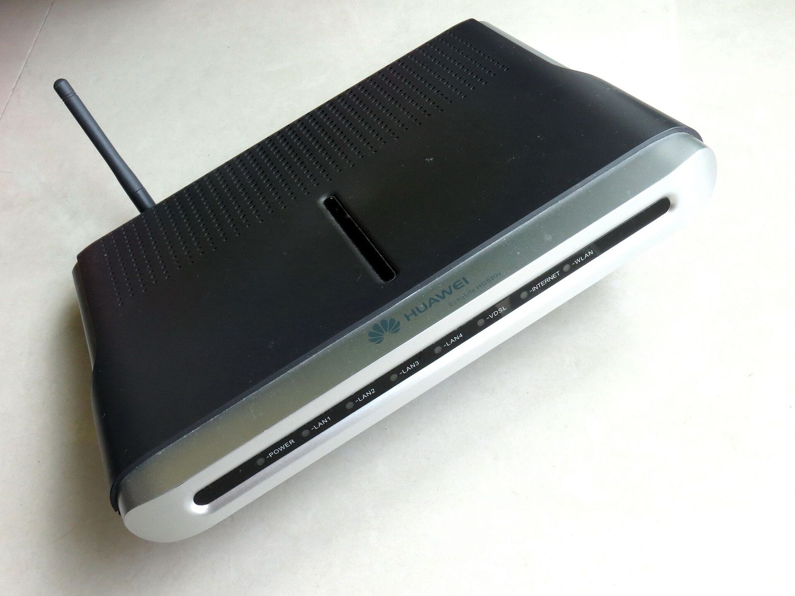 A home internet router and gateway box on a surface.